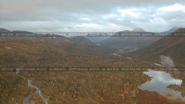Aerial view of autumn colorful forest, lakes and swamps under the cloudy sky. Стоковое фото, фотограф David Kashakhi / Фотобанк Лори
