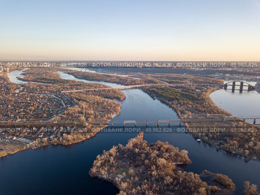 Aerial view of Kiev, Ukraine. Panorama of the right bank of the city and the flood of the Dnieper River with the Petrovsky railway bridge and the unfinished Podolsky bridge. Left bank of the city with private houses, Ukraine. Landscaped view of the city of Kiev with the Dnieper River, the left side of the city. Стоковое фото, агентство Ingram Publishing / Фотобанк Лори