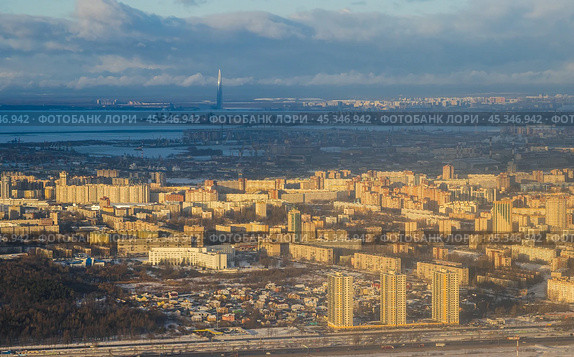 Aerial view of the city of St. Petersburg. Winter cityscape. Top view of city blocks with high-rise buildings. A tall skyscraper in the distance on the coast. Panorama of Saint-Petersburg, Russia. Стоковое фото, фотограф Андрей Степанов / Фотобанк Лори