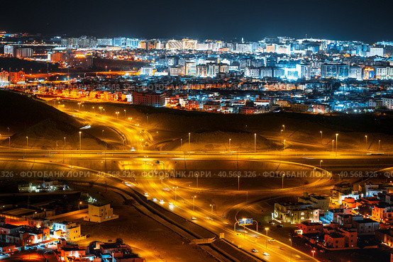 Aerial view of the night city of Muscat - the capital of the Sultanate of Oman. Road junctions and houses illuminated at night. Стоковое фото, фотограф Евгений Ткачёв / Фотобанк Лори