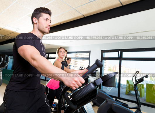 Aerobics elliptical walker trainer group at fitness gym workout. Стоковое фото, агентство Ingram Publishing / Фотобанк Лори