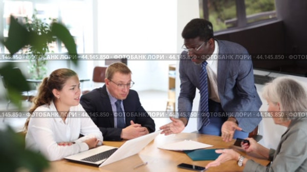 African man auditor speaks about trouble before meeting of frowning shareholders of businessmen. Стоковое видео, видеограф Яков Филимонов / Фотобанк Лори