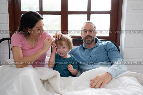 After the little boy wakes up from his nap, his father and mother engage in enjoyable activities in his bedroom. Стоковое фото, агентство Ingram Publishing / Фотобанк Лори