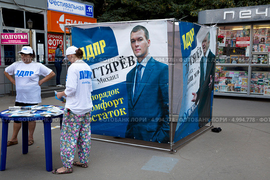 Агитационная точка (Куб) кандидата в мэры города Москвы Михаила Дегтярева партия ЛДПР около входа в метро в городе Москве (2013 год). Редакционное фото, фотограф Николай Винокуров / Фотобанк Лори