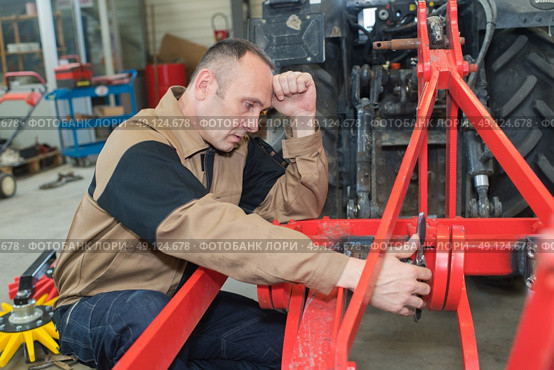 Agricultural mechanic looking stressed. Стоковое фото, агентство Ingram Publishing / Фотобанк Лори