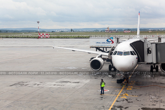 Aircraft of Ural Airlines is connected with passenger boarding bridge to airport terminal. The Koltsovo International Airport. Екатеринбург (2015 год). Редакционное фото, фотограф Кекяляйнен Андрей / Фотобанк Лори