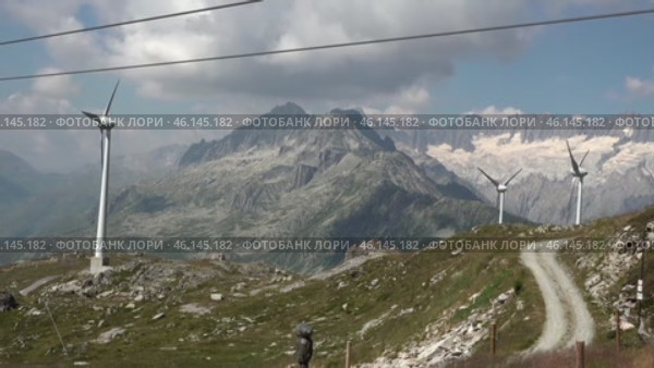 Альпы и ветряки с вершины горы Gutsch. Андерматт. Швейцария. Июль. Alps and windmills from the top of Mount Gutsch. Andermatt. Switzerland. July. Стоковое видео, видеограф Горшков Александр / Фотобанк Лори