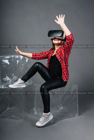 amazed young woman touching air during vr experience. Стоковое фото, агентство Ingram Publishing / Фотобанк Лори