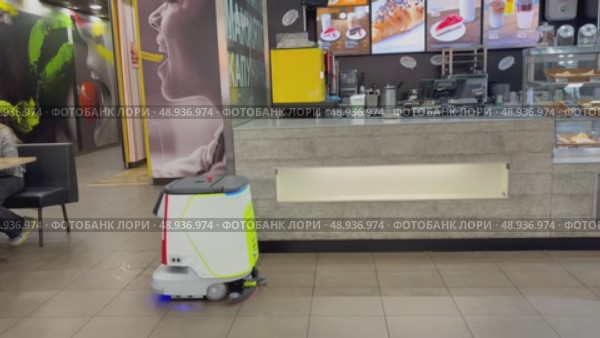 An autonomous cleaning robot moving across the shiny floor of the Vkusno i Tochka restaurant, emphasizing its modern technologies, Vkusno i tochka, Russia, Moscow, 05.05.2025. Редакционное видео, видеограф Терехова Марина / Фотобанк Лори