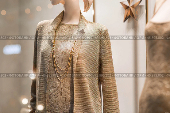 An elegant showcase of an expensive luxury store with stylish mannequins in clothes and evening lighting. The concept of shopping and sales. Стоковое фото, фотограф Photojuli / Фотобанк Лори