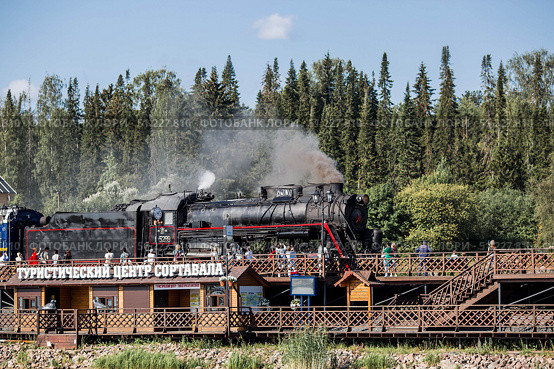 An old Soviet steam locomotive of the L series. The Ruskeala Express retro train is on its way to the mountain park. Thick smoke is coming from the chimney. Russia, Republic of Karelia, Sortavala, August 10, 2025. Редакционное фото, фотограф Photojuli / Фотобанк Лори