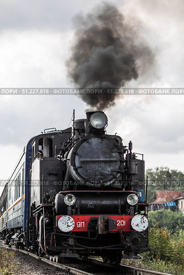 An old Soviet steam locomotive of the L series. The Ruskeala Express retro train is on its way to the mountain park. Thick smoke is coming from the chimney. Russia, Republic of Karelia, Sortavala, August 10, 2025. Редакционное фото, фотограф Photojuli / Фотобанк Лори