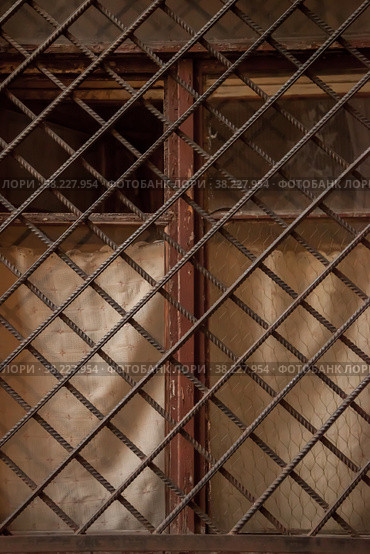 An old vintage window with heavy metal construction bars. Window with an open pane and lattice in Old city. Background. Security from burglary of apartment. Construction and design concept. Стоковое фото, фотограф Aleksandr Golubev / Фотобанк Лори