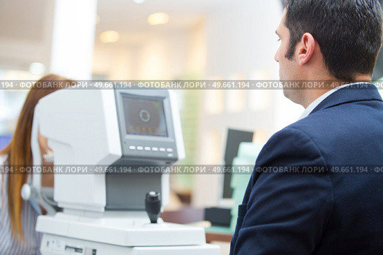 an optician examining patients eyes. Стоковое фото, агентство Ingram Publishing / Фотобанк Лори