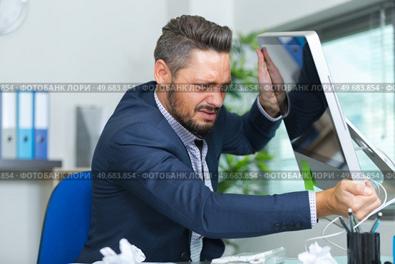 angry man hitting the computer screen. Стоковое фото, агентство Ingram Publishing / Фотобанк Лори