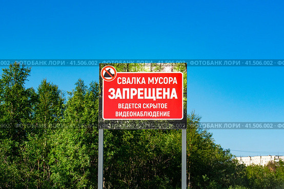 Аншлаг "Свалка мусора запрещена" на фоне зеленых деревьев. Стоковое фото, фотограф Анна Аникова / Фотобанк Лори