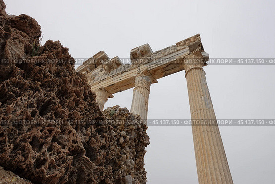 Античные колонны на фоне скал. Храм Аполлона античный город Сиде. Ancient columns against the backdrop of cliffs. The Temple of Apollo in the ancient city of Side. Стоковое фото, фотограф Юрий Пуликов / Фотобанк Лори