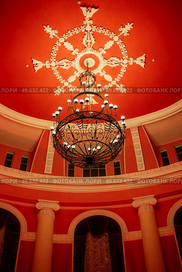 antique ceiling chandelier with lamps in red light on vaulted ceiling. Стоковое фото, агентство Ingram Publishing / Фотобанк Лори