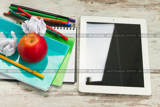 Apple with school supplies and tablet on white wooden table. Apple with school supplies. Стоковое фото, агентство Ingram Publishing / Фотобанк Лори