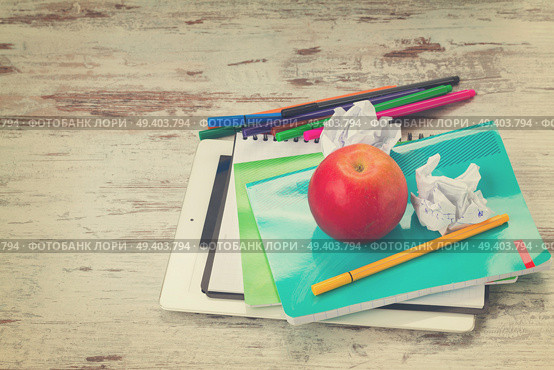 Apple with school supplies on aged white wooden table, retro toned. Apple with school supplies. Стоковое фото, агентство Ingram Publishing / Фотобанк Лори