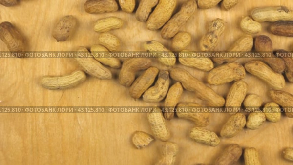 Арахис, падающий на деревянный фон, вид сверху. peanuts  falling on the wooden background. Стоковое видео, видеограф Александр Собко / Фотобанк Лори