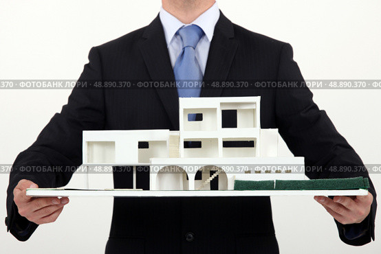 Architect holding scale replica of building. Стоковое фото, агентство Ingram Publishing / Фотобанк Лори