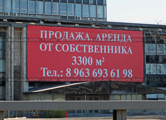Аренда, продажа помещений. Объявление на вывеске, висящей на стене здания (Москва, Ленинградское шоссе) (2015 год). Редакционное фото, фотограф Александр Замараев / Фотобанк Лори