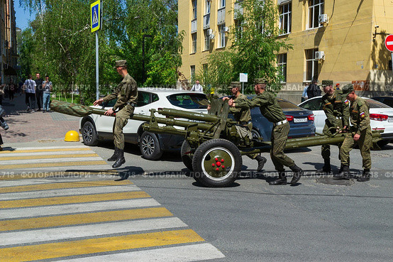 Артиллеристы салютного дивизиона катят вручную по улице 76мм дивизионную пушку ЗИС-3. Волгоград, улица Мира, Россия (2024 год). Редакционное фото, фотограф Андрей Цыганков / Фотобанк Лори