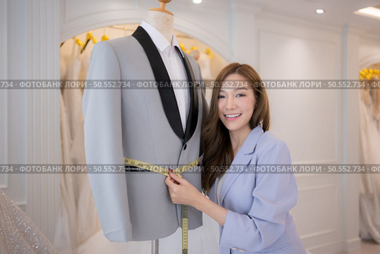 Asian fashion designers make sure the groom’s outfit is absolutely accurate and ready for the bride and groom to try on. Стоковое фото, агентство Ingram Publishing / Фотобанк Лори