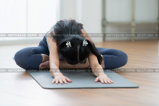 Asian young women doing yoga exercises during their holiday at home. Стоковое фото, агентство Ingram Publishing / Фотобанк Лори