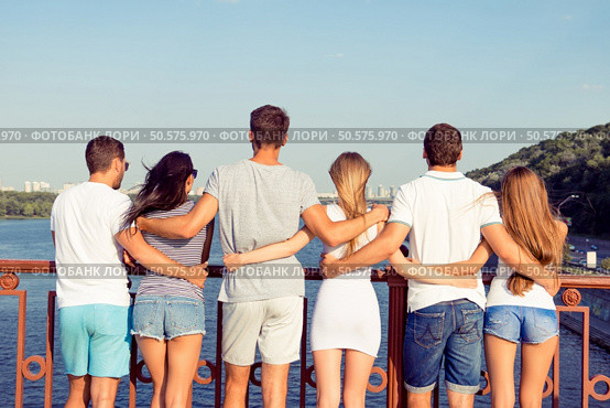 at summer holidays group of friendly students hugging on city embankment. Стоковое фото, агентство Ingram Publishing / Фотобанк Лори