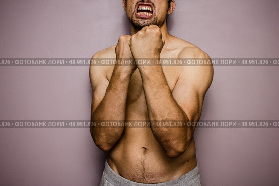 Athletic young man with his fists raised. Стоковое фото, агентство Ingram Publishing / Фотобанк Лори