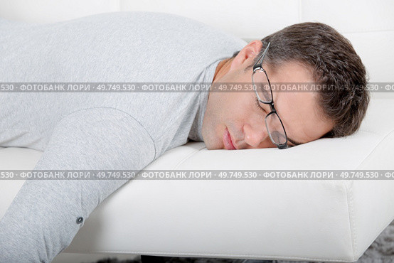 attractive man with glasses napping on the couch. Стоковое фото, агентство Ingram Publishing / Фотобанк Лори