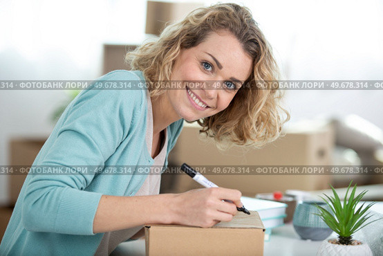 attractive woman signing on delivery paper. Стоковое фото, агентство Ingram Publishing / Фотобанк Лори