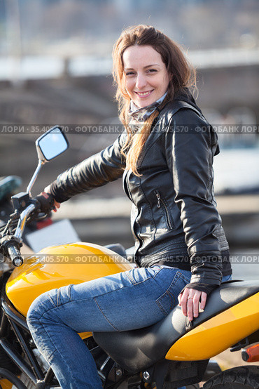 Attractive woman with her motorcycle, looking at camera. Стоковое фото, фотограф Кекяляйнен Андрей / Фотобанк Лори