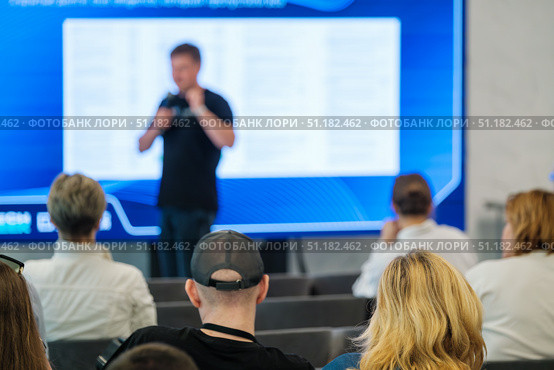 Audience listens to speaker at seminar with screen in background. Стоковое фото, фотограф Антон Гвоздиков / Фотобанк Лори