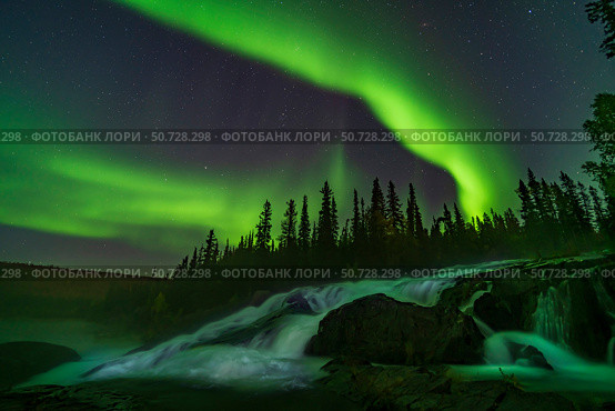 Auroral curtains over Ramparts Falls on the Cameron River, Canada. Стоковое фото, фотограф Alan Dyer/Stocktrek Images / ТАСС / Фотобанк Лори