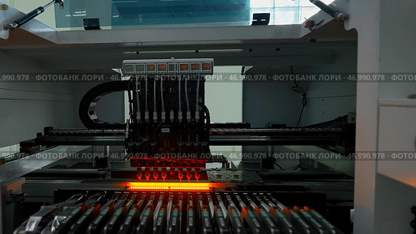 Automatic pick and place machine is installing components on circuit board. Стоковое фото, фотограф David Kashakhi / Фотобанк Лори