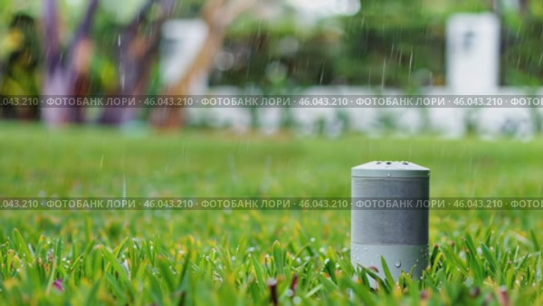 Automatic reinforced sensor stands on a green lawn, during the rain. Стоковое AI-видео, аниматор Zakharova Natasha / Фотобанк Лори