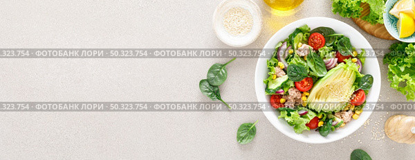 Avocado and tuna fresh vegetable salad with tomato, cucumber corn, onion, lettuce and spinach. Healthy and detox food concept. Ketogenic diet. Buddha bowl dish on light background, top view. Banner. Стоковое фото, агентство Ingram Publishing / Фотобанк Лори