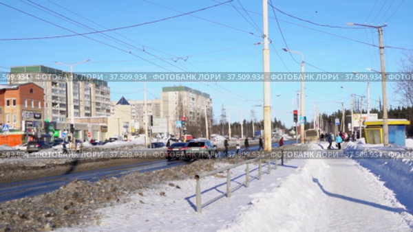 Автомашины на шоссе останавливаются на красный свет светофора перед пешеходным переходом в городе весной в замедленной съемке. Редакционное видео, видеограф Sergei Gorin / Фотобанк Лори
