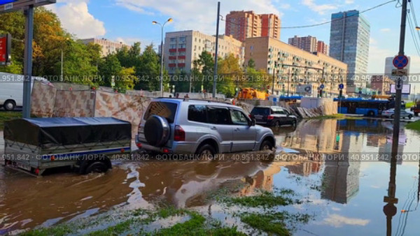 Автомобиль с прицепом едет по глубокому скоплению воды на дороге. Проспект Вернадскоо. Москва. Редакционное видео, видеограф Татьяна Бакуменко / Фотобанк Лори