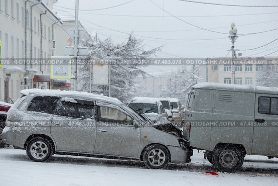 Автомобильная авария на городской улице. Машина врезалась в другую машину на скользкой заснеженной дороге. Сложные дорожные условия во время снегопада. Снежная зимняя погода. Стоковое фото, фотограф Андрей Степанов / Фотобанк Лори