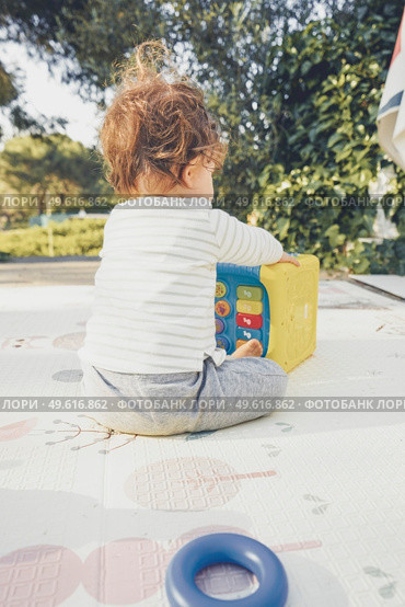 Backview of a baby playing in nature. Стоковое фото, агентство Ingram Publishing / Фотобанк Лори