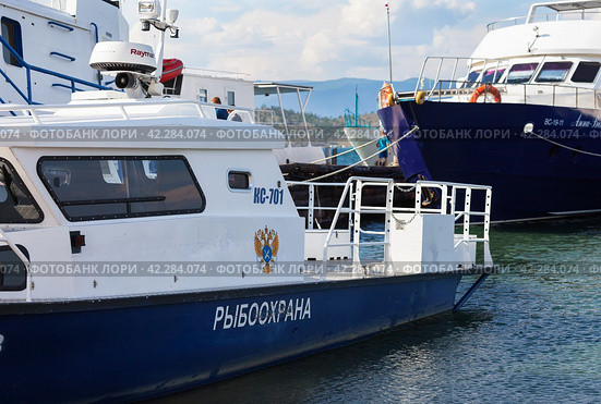 BAIKAL LAKE, SAKHYURTA VILLAGE, IRKUTSK REGION, RUSSIA - August 14, 2023: The regional fisheries protection ship at the pier on the shore of the Small Sea on a sunny summer day. Редакционное фото, фотограф Виктория Катьянова / Фотобанк Лори