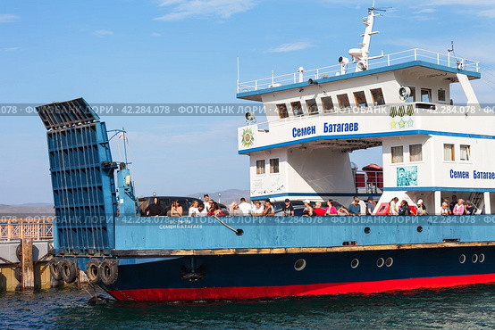 BAIKAL LAKE, SAKHYURTA VILLAGE, IRKUTSK REGION, RUSSIA - August 14, 2023: Passenger ferry carries tourists through Olkhon Gate Strait to picturesque Olkhon Island - popular holiday destination. Редакционное фото, фотограф Виктория Катьянова / Фотобанк Лори