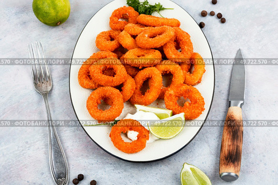 Baked breaded calamari or octopus rings on brown concrete table.. Rings of squid. Стоковое фото, агентство Ingram Publishing / Фотобанк Лори