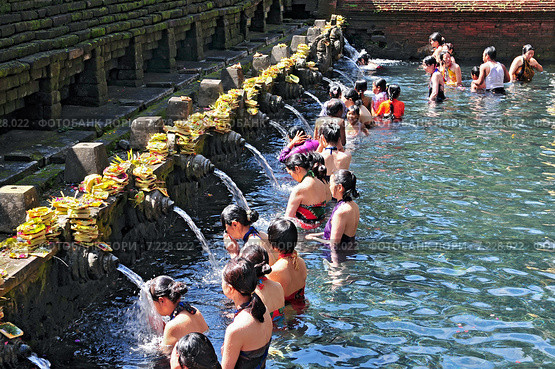 Balinese Hindu families come to the sacred springs of Tirta Empul in Bali, Indonesia to pray and cleanse their soul. Редакционное фото, агентство BE&W Photo / Фотобанк Лори