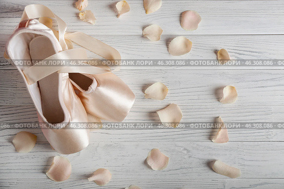 Ballet shoes with flower petals on wooden floor. Стоковое фото, фотограф Pixel_shot / Фотобанк Лори