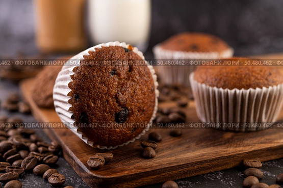 Banana cupcakes that are placed on a wooden plate with coffee grains. Selelctive focus. Стоковое фото, агентство Ingram Publishing / Фотобанк Лори